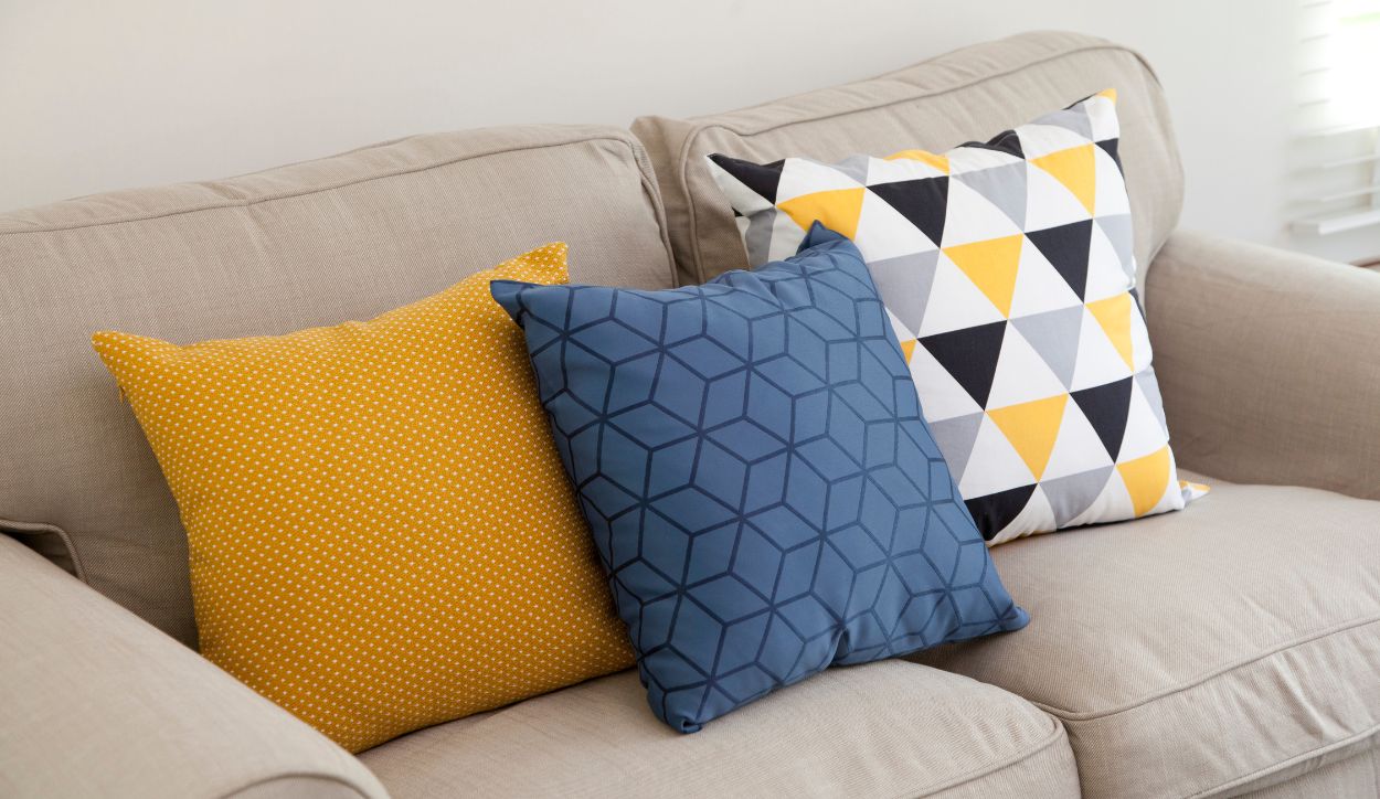Immagine di una disposizione di cuscini su di un divano in modo simmetrico.